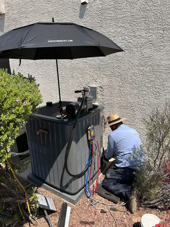 HVAC technician performing outdoor AC maintenance in El Dorado