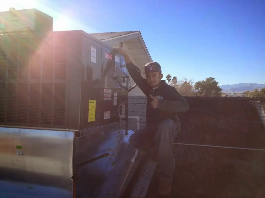 HVAC technician performing HVAC Inspection on a rooftop unit in El Dorado